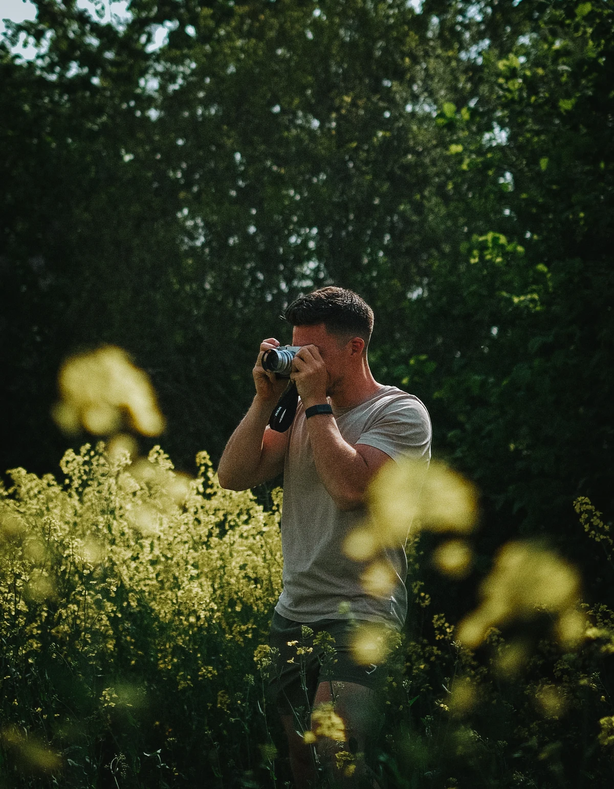 Karim fotograferer med kameraet i hænderne ude i naturen
