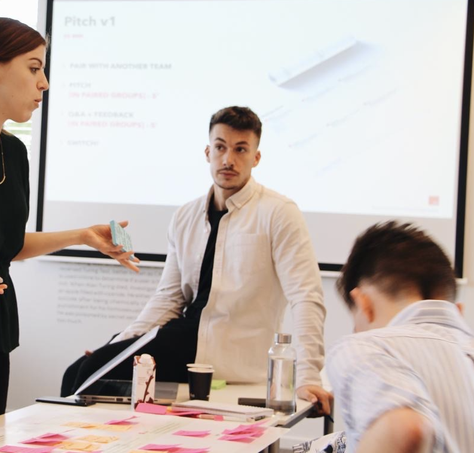 Karim faciliterer en workshop med et team omkring bordet